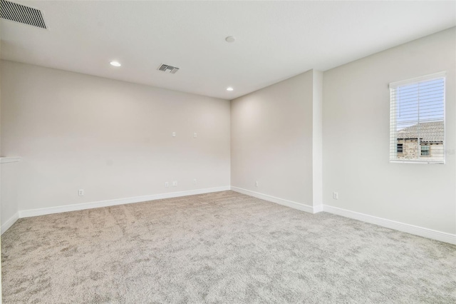 carpeted spare room featuring baseboards, visible vents, and recessed lighting