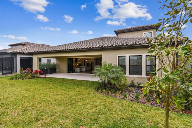 rear view of property with a yard, a patio, stucco siding, and a tile roof