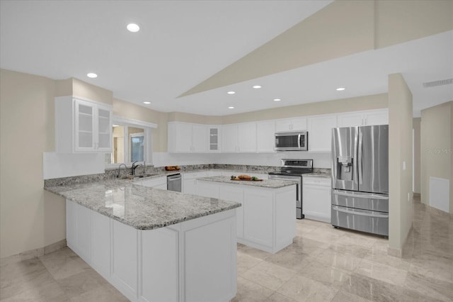 3506 Seaway Dr, New Port Richey, FL 34652 - kitchen with visible vents, a sink, appliances with stainless steel finishes, a peninsula, and light stone counters
