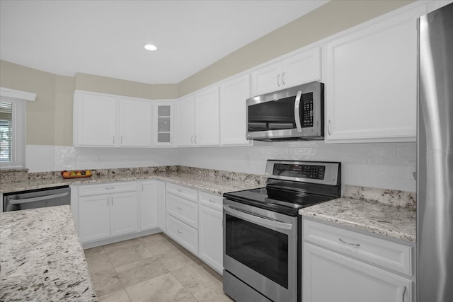 3506 Seaway Dr, New Port Richey, FL 34652 - kitchen featuring glass insert cabinets, white cabinets, appliances with stainless steel finishes, light stone countertops, and backsplash