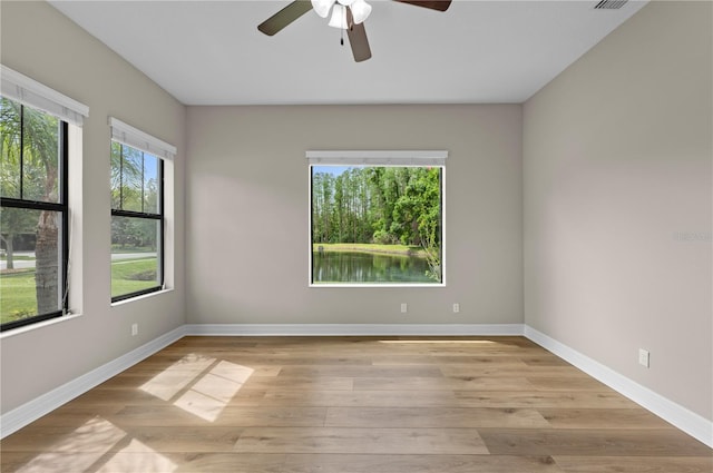 unfurnished room featuring baseboards, a ceiling fan, and light wood-style flooring
