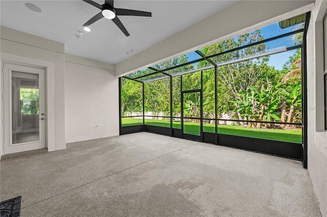 unfurnished sunroom with ceiling fan