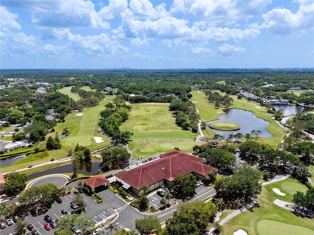 drone / aerial view with golf course view, a residential view, and a water view