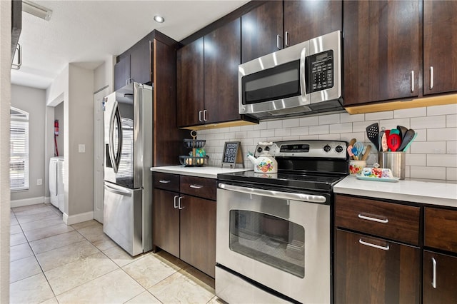 14910 Par Club Cir, Tampa, FL 33618 - kitchen with baseboards, light tile patterned floors, light countertops, backsplash, and appliances with stainless steel finishes