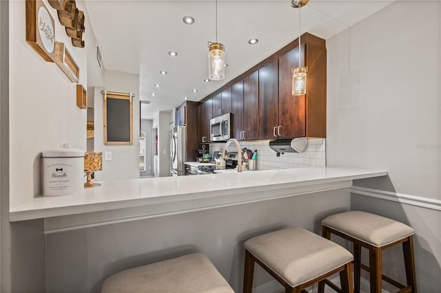 14910 Par Club Cir, Tampa, FL 33618 - kitchen featuring dark brown cabinetry, recessed lighting, backsplash, stainless steel appliances, and pendant lighting