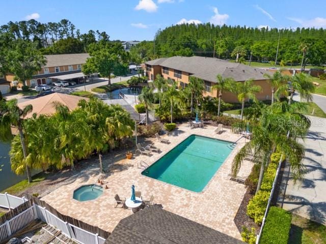 14910 Par Club Cir, Tampa, FL 33618 - community pool featuring a patio area, a community hot tub, a forest view, and fence