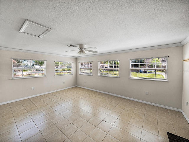 tiled empty room with a textured ceiling, attic access, and ornamental molding