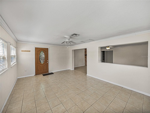 interior space featuring crown molding, light tile patterned floors, a ceiling fan, visible vents, and baseboards