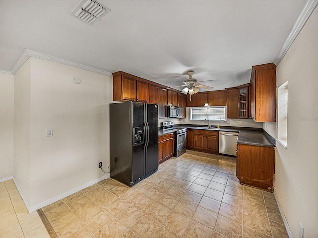kitchen with appliances with stainless steel finishes, dark countertops, visible vents, ceiling fan, and a sink