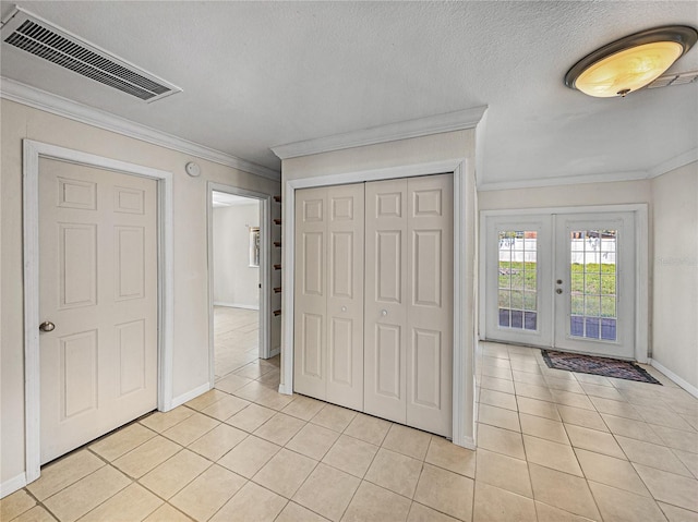 unfurnished bedroom featuring baseboards, light tile patterned floors, french doors, crown molding, and visible vents