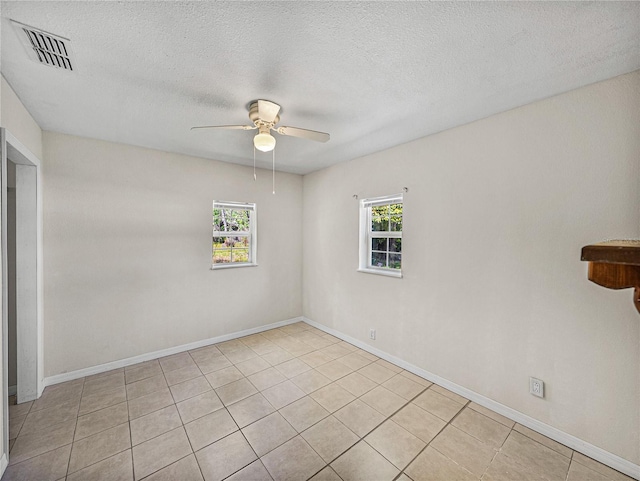 spare room with visible vents, baseboards, a ceiling fan, and light tile patterned floors