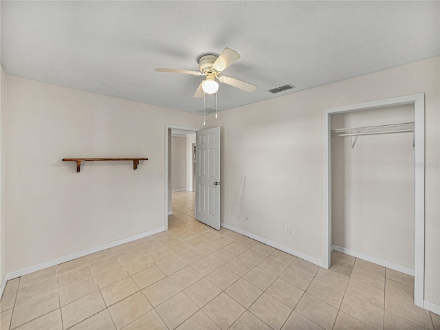 unfurnished bedroom with light tile patterned floors, visible vents, a closet, and ceiling fan