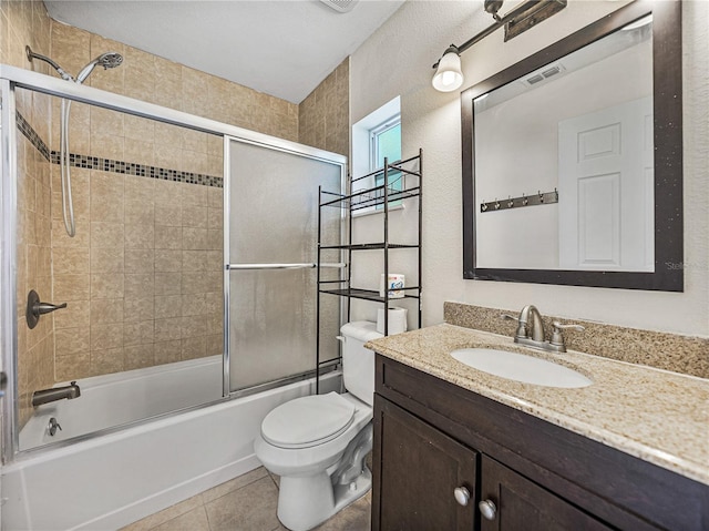 bathroom featuring shower / bath combination with glass door, vanity, tile patterned flooring, toilet, and visible vents