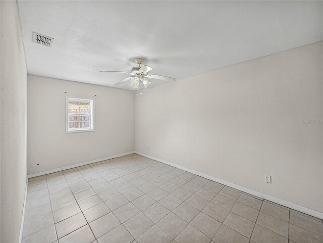 unfurnished room with light tile patterned floors, visible vents, baseboards, and ceiling fan