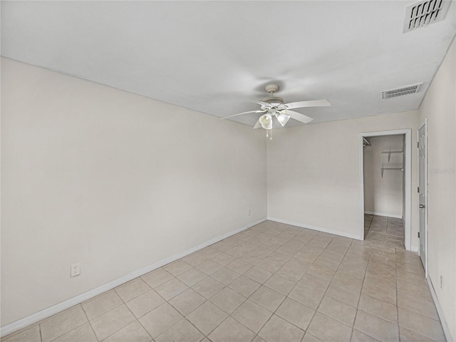 empty room with visible vents, ceiling fan, and baseboards