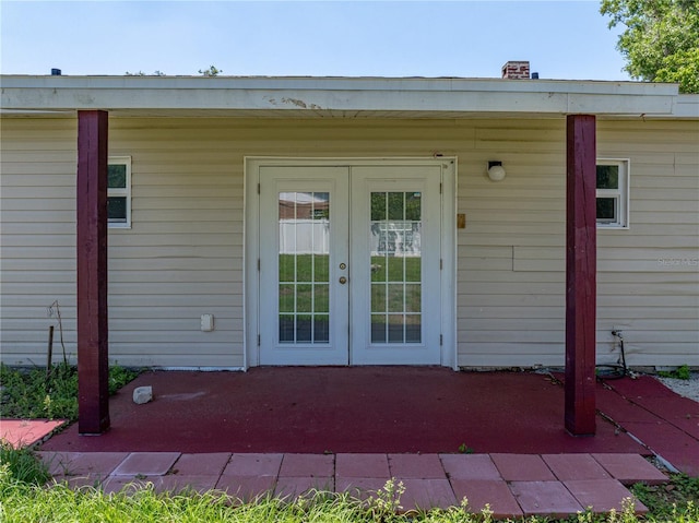 doorway to property featuring french doors, a patio, and a chimney