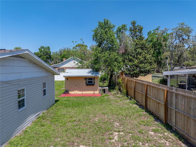 view of yard featuring a storage shed, fence, and an outdoor structure