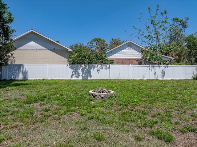 view of yard featuring fence and an outdoor fire pit