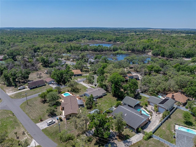 aerial view featuring a wooded view and a water view
