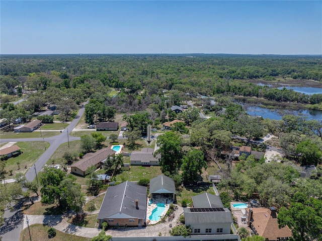 birds eye view of property featuring a wooded view, a residential view, and a water view