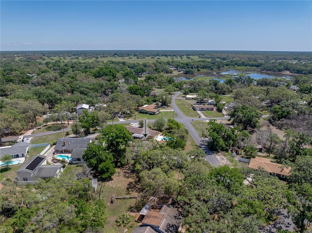 birds eye view of property featuring a water view and a view of trees