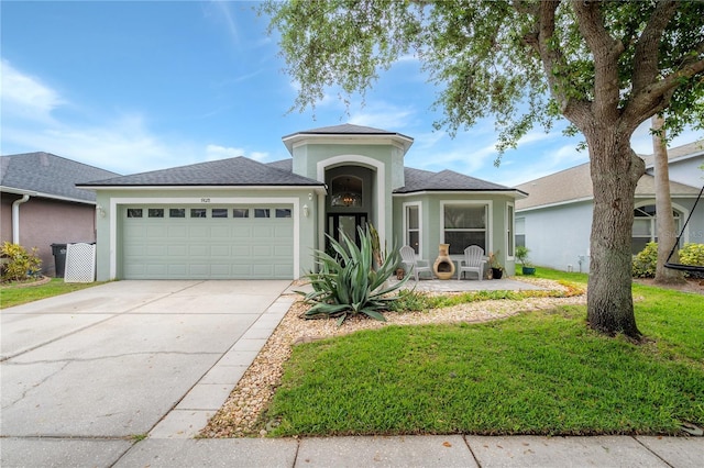 ranch-style home featuring a garage, a front lawn, roof with shingles, stucco siding, and concrete driveway