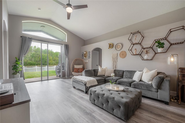 living room featuring arched walkways, ceiling fan, wood finished floors, and lofted ceiling