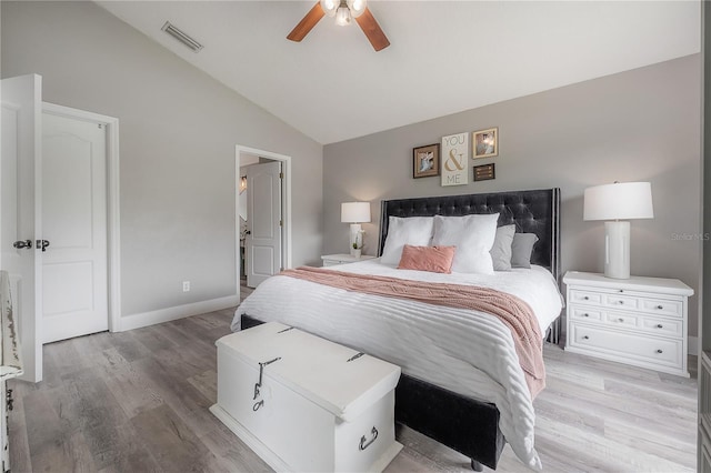 bedroom with light wood finished floors, a ceiling fan, baseboards, lofted ceiling, and visible vents