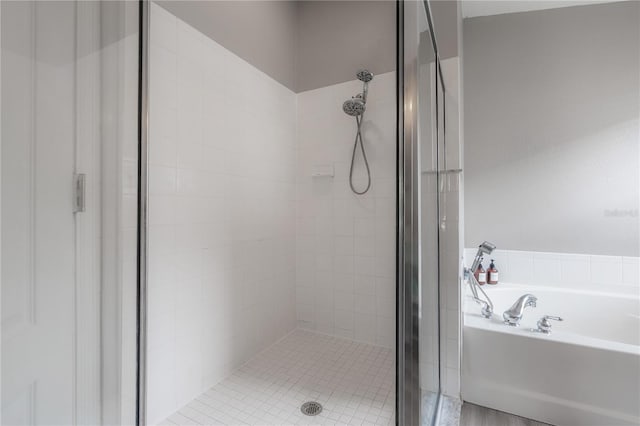full bath with a stall shower and a garden tub