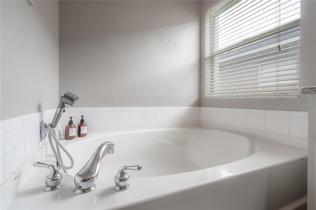 full bathroom with a garden tub and a textured wall