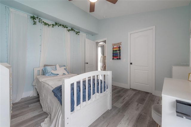 bedroom with baseboards, a ceiling fan, and wood finished floors