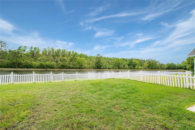 view of yard with a water view and fence