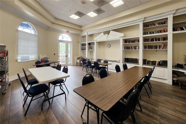 dining room with a tray ceiling, a drop ceiling, and dark wood-type flooring