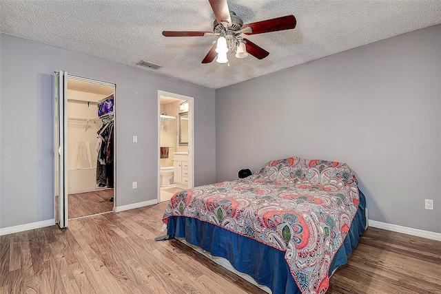 3647 Lake St, George Drive, Palm Harbor, FL 34684 - bedroom featuring wood finished floors, a textured ceiling, ceiling fan, a spacious closet, and ensuite bathroom