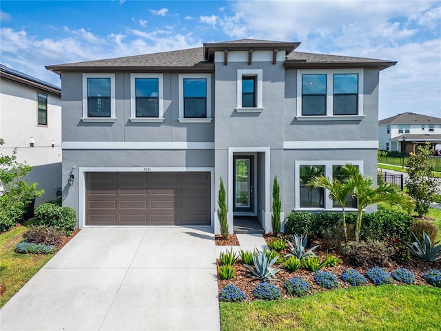 view of front of home featuring a garage, driveway, stucco siding, and a shingled roof