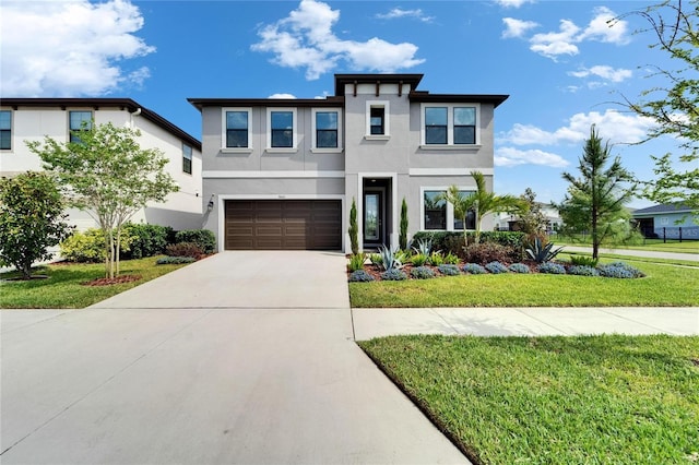 contemporary home with an attached garage, driveway, stucco siding, and a front lawn