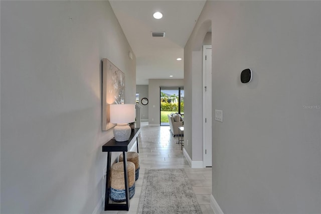 hall with recessed lighting, arched walkways, visible vents, and baseboards