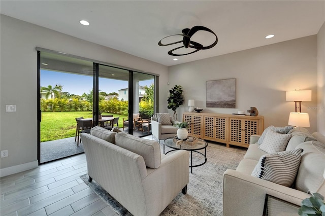 living area with recessed lighting, baseboards, and a ceiling fan