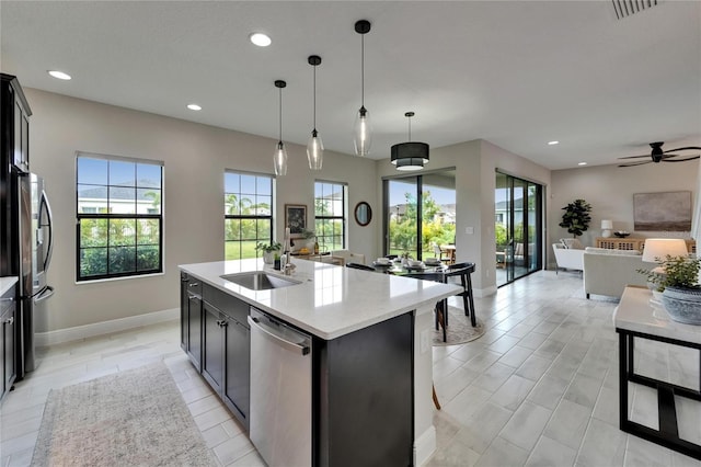 kitchen featuring plenty of natural light, a sink, open floor plan, appliances with stainless steel finishes, and recessed lighting