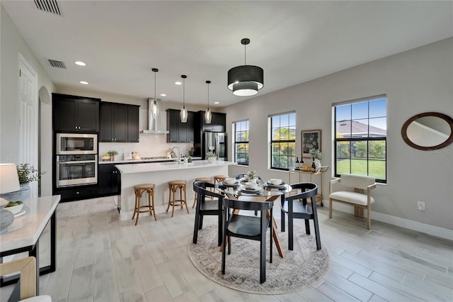 dining room featuring recessed lighting, light wood finished floors, visible vents, and baseboards