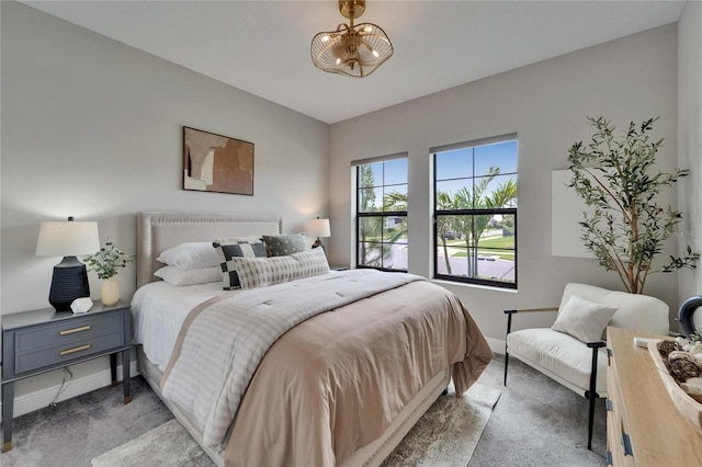 bedroom with baseboards and light colored carpet