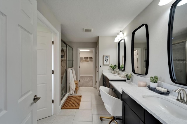 full bathroom featuring a stall shower, a sink, tile patterned flooring, and visible vents