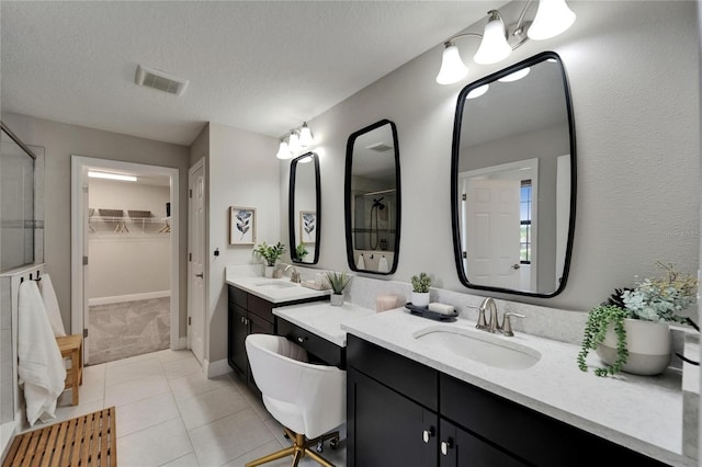 full bath with a shower stall, tile patterned flooring, visible vents, and a sink
