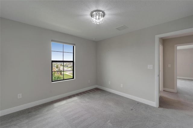 carpeted spare room with a chandelier and baseboards