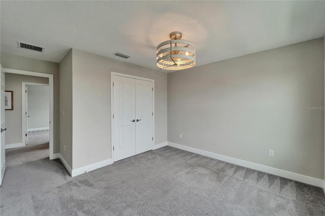 unfurnished bedroom featuring visible vents, baseboards, a closet, and carpet floors