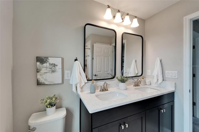 bathroom featuring a sink, toilet, and double vanity