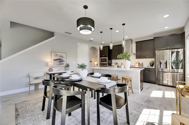 5601 Limelight Dr, Apollo Beach, FL 33572 - dining area featuring arched walkways, recessed lighting, and light wood-style flooring