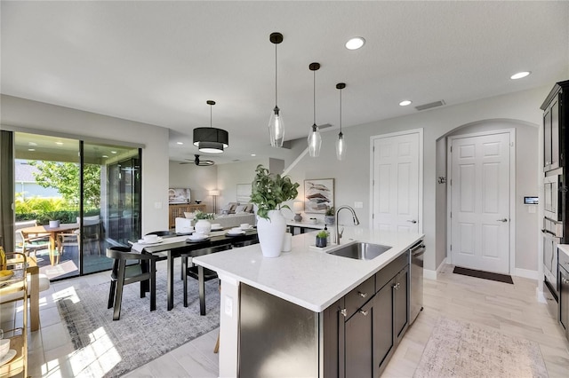 5601 Limelight Dr, Apollo Beach, FL 33572 - kitchen featuring appliances with stainless steel finishes, light countertops, arched walkways, ceiling fan, and hanging light fixtures