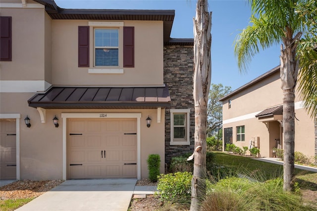 11704 Castine St, New Port Richey, FL 34654 - townhome / multi-family property with a standing seam roof, metal roof, stucco siding, concrete driveway, and stone siding