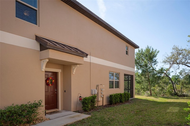 11704 Castine St, New Port Richey, FL 34654 - view of side of property with stucco siding and a lawn